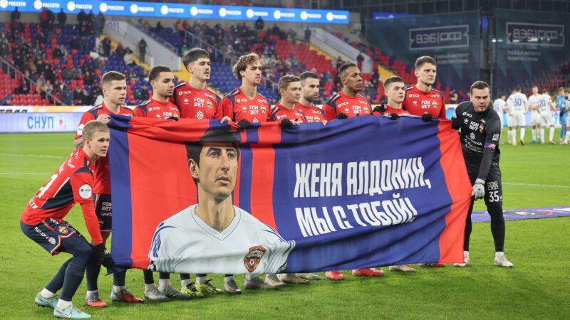 Игроки ЦСКА держат баннер с поддержкой Евгения Алдонина